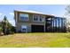 Rear exterior view of the home showcasing the screened-in pool area and lush backyard at 3712 Balboa Ct, Punta Gorda, FL 33983