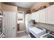 Bright laundry room with white cabinets and modern appliances, including a sink and washer dryer at 3712 Balboa Ct, Punta Gorda, FL 33983