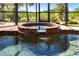 Close-up of the spa with a waterfall flowing into the clear pool, encased in a screened enclosure at 3712 Balboa Ct, Punta Gorda, FL 33983