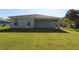 A sprawling backyard offers a tranquil view of the home's exterior and a covered patio space at 4071 Conestoga St, Port Charlotte, FL 33948