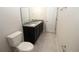 Bright bathroom featuring a granite countertop, dark vanity, and modern fixtures at 4071 Conestoga St, Port Charlotte, FL 33948