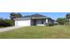 Well-maintained one-story home with a lush green lawn and a paved driveway at 4071 Conestoga St, Port Charlotte, FL 33948