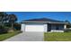 Charming single-story home with a two-car garage, landscaped lawn, and a paved driveway at 4071 Conestoga St, Port Charlotte, FL 33948