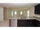 Open-concept kitchen featuring dark cabinets, stainless steel appliances, and an adjacent living area at 4071 Conestoga St, Port Charlotte, FL 33948