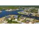 Elevated view of a home with a private dock, lush landscaping, and waterway access in a residential neighborhood at 4174 Perch Cir, Port Charlotte, FL 33948