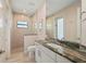 Bright bathroom featuring white cabinetry, granite counters, tiled flooring, and a walk-in shower at 4174 Perch Cir, Port Charlotte, FL 33948