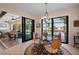 Elegant dining area with a glass table, stylish chairs, and a view of the pool and waterway at 4174 Perch Cir, Port Charlotte, FL 33948