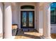 Close-up of the front door, framed by columns and featuring decorative glass inserts at 4174 Perch Cir, Port Charlotte, FL 33948