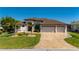Attractive home with a three-car garage, well-kept lawn, and a brick-paved driveway at 4174 Perch Cir, Port Charlotte, FL 33948
