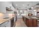 Open kitchen with white cabinets, stainless appliances, an island with seating and stylish pendant lighting at 4174 Perch Cir, Port Charlotte, FL 33948