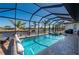 Sparkling pool area offers serene waterfront views with palm trees and a private dock at 4174 Perch Cir, Port Charlotte, FL 33948