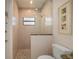 Walk-in shower featuring natural stone accents, a shower head, and tiled walls at 4174 Perch Cir, Port Charlotte, FL 33948