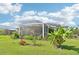 A spacious backyard featuring a screened-in lanai, vibrant plants, and a well-maintained lawn at 4463 Cromey Rd, North Port, FL 34288
