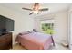 Cozy bedroom with a ceiling fan, a comfortable bed, and a large window at 4463 Cromey Rd, North Port, FL 34288