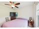 Cozy bedroom with ceiling fan, television, wooden nightstand, and quaint chair at 4463 Cromey Rd, North Port, FL 34288