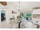 Elegant dining area featuring modern chandelier, a glass-top table, and sliding glass doors leading to the outdoor patio at 4463 Cromey Rd, North Port, FL 34288