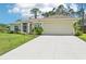 Well-maintained single-story home with an attached two-car garage and concrete driveway, surrounded by lush greenery at 4463 Cromey Rd, North Port, FL 34288