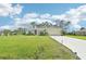 Inviting home with a sprawling green lawn, mature trees, and a freshly paved driveway at 4463 Cromey Rd, North Port, FL 34288