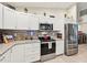 Modern kitchen with stainless steel appliances, granite countertops, white cabinets and tile backsplash at 4463 Cromey Rd, North Port, FL 34288
