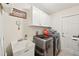 Convenient laundry room with washer, dryer, storage cabinets, and utility sink at 4463 Cromey Rd, North Port, FL 34288