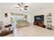 Bright living room with tile floors, a ceiling fan, comfortable seating, and large-screen television for entertainment at 4463 Cromey Rd, North Port, FL 34288