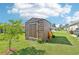Outdoor storage shed with backyard landscaping and green lawn at 4463 Cromey Rd, North Port, FL 34288