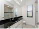 Bathroom features a sleek black countertop, modern fixtures, and a glass enclosed shower at 4676 Tuscana Dr, Sarasota, FL 34241