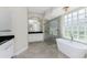 Bright bathroom features a freestanding tub, separate shower, and black countertop on the vanity at 4676 Tuscana Dr, Sarasota, FL 34241