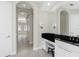 Bathroom vanity with black countertop, make up area and arched doorway to bedroom with natural light at 4676 Tuscana Dr, Sarasota, FL 34241