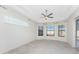 Spacious bedroom featuring tray ceilings, tile flooring, and an abundance of natural light through large windows at 4676 Tuscana Dr, Sarasota, FL 34241