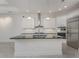 Modern kitchen boasts stainless steel appliances, an island, and white cabinetry at 4676 Tuscana Dr, Sarasota, FL 34241