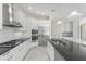 Well-equipped kitchen with gas cooktop, island sink, stainless steel appliances, and white cabinets at 4676 Tuscana Dr, Sarasota, FL 34241