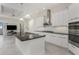 Bright kitchen features an island with sink, modern stainless hood, and white cabinets at 4676 Tuscana Dr, Sarasota, FL 34241