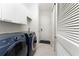 Bright laundry room with modern washer, dryer, white cabinets, and ample storage space at 4676 Tuscana Dr, Sarasota, FL 34241