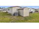 Mobile home backyard with a shed and central AC at 5488 Holiday Park Blvd, North Port, FL 34287