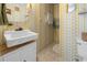 Bathroom features a pedestal sink, patterned wallpaper, and a neutral floor at 5488 Holiday Park Blvd, North Port, FL 34287