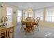 Bright dining room featuring classic wood furniture, natural light, and carpet flooring at 5488 Holiday Park Blvd, North Port, FL 34287