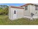 Exterior angle showing home's siding, white door with window, and small area of grass at 5488 Holiday Park Blvd, North Port, FL 34287