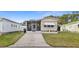 Charming single-story home featuring a screened porch, awning, and well-manicured lawn at 5488 Holiday Park Blvd, North Port, FL 34287