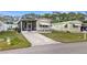 Charming single-story home featuring a screened porch, awning, and well-manicured lawn at 5488 Holiday Park Blvd, North Port, FL 34287