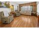 Comfortable living room features plush seating, wood-paneled walls, and bright windows at 5488 Holiday Park Blvd, North Port, FL 34287