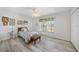 Cozy bedroom with light wood floors, a ceiling fan, and a window with natural light at 5640 Burdette Ter, North Port, FL 34287