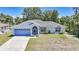 Charming single-story home with a blue color scheme and a well-manicured lawn at 5640 Burdette Ter, North Port, FL 34287