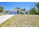 Inviting single-story home featuring a blue garage door and lush, green front lawn at 5640 Burdette Ter, North Port, FL 34287