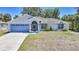 Charming single-story home with a blue garage door, screened porch, and well-maintained front yard at 5640 Burdette Ter, North Port, FL 34287