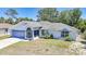 Charming single-story home with a well-manicured lawn, attached garage, and screened-in front porch at 5640 Burdette Ter, North Port, FL 34287