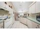 Efficient kitchen featuring white appliances, tile floors, and breakfast bar at 5640 Burdette Ter, North Port, FL 34287