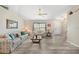 Bright living room featuring wood-look floors, a ceiling fan, and neutral walls at 5640 Burdette Ter, North Port, FL 34287