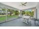 Relaxing screened porch with ceiling fan and outdoor seating area overlooking the backyard at 5640 Burdette Ter, North Port, FL 34287