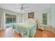Bright bedroom with wood floors, ceiling fan, and sliding glass doors to the pool at 657 Hartford Nw Dr, Port Charlotte, FL 33952